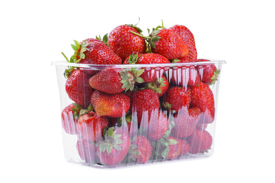 Fresh ripe strawberries in transparent punnet or plastic box, container isolated on white background. Sweet juicy berries ready for healthy food snacking, desserts and summer recipes.