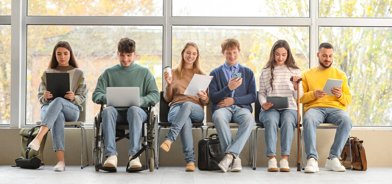 Young job applicants with man in wheelchair waiting for interview at office