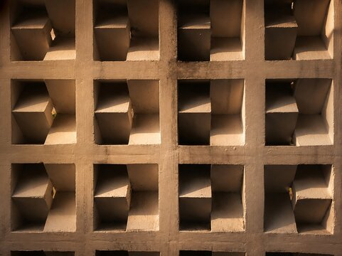 Modern minimalist concrete breeze block wall texture with geometric square pattern and shadows