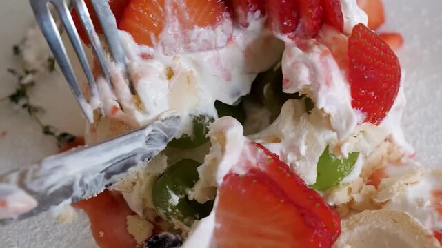 A professional chef in white gloves meticulously plates a delicate, charred cornhusk-flavored meringue. The chef fills the hollow center with a creamy sweet corn mousse and finishes the upscale desser
