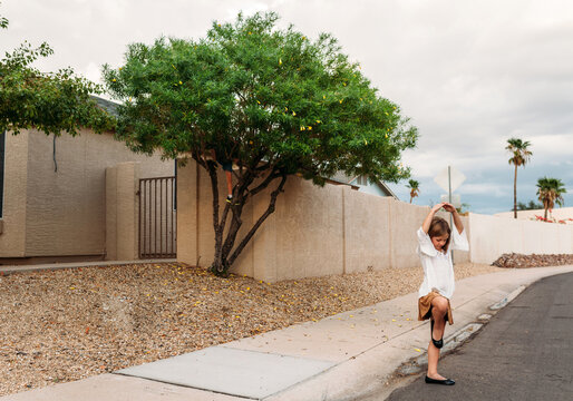 Girl dancing on sidewalk