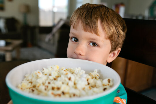 Boy holding popcorn bowl
