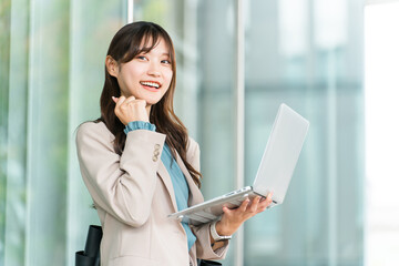 Fototapeta premium Stylish woman/designer/businesswoman with a laptop (investing, side hustle, triumphant pose)