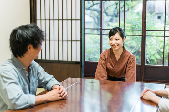 老舗の温泉旅館・高級旅館の客室で夫婦,カップルに挨拶をする仲居さん・女将さん