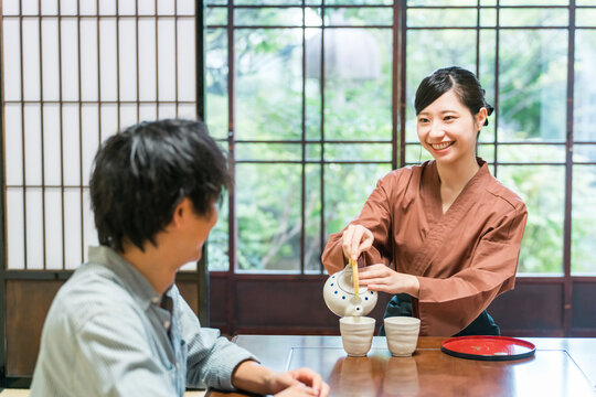 温泉旅館の客室でお茶を淹れる旅館スタッフ・仲居さんの女性