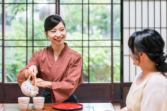 温泉旅館の客室でお茶を淹れる旅館スタッフ・仲居さんの女性