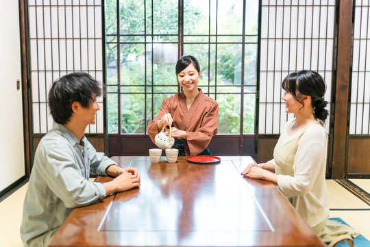 温泉旅館の客室でお茶を淹れる旅館スタッフ・仲居さんの女性