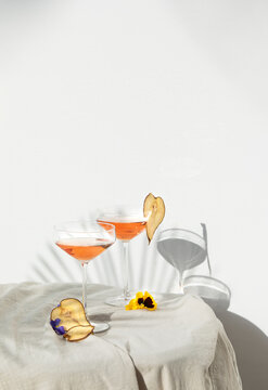 Two rose wine glasses with summer cocktails and dried fruit appetizers
