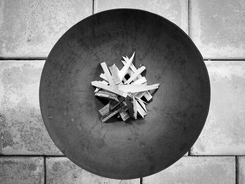Round metal fire pit with wood kindling top view in outdoor patio in black and white