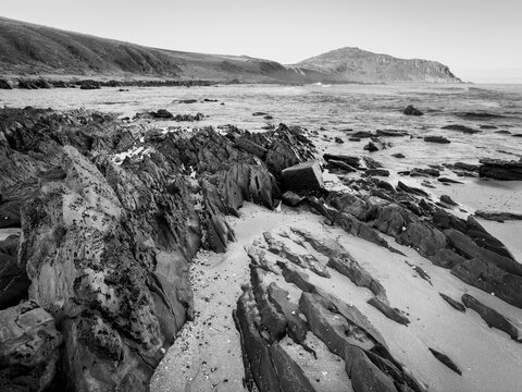 Landscape views of rocks and ocean from beaches along the Victor Harbor Heritage Trail on the Fleurieu Peninsula in South Australia in dramatic black and white