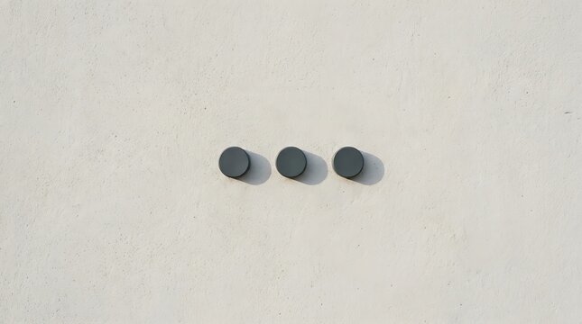 Three black circular knobs on white wall