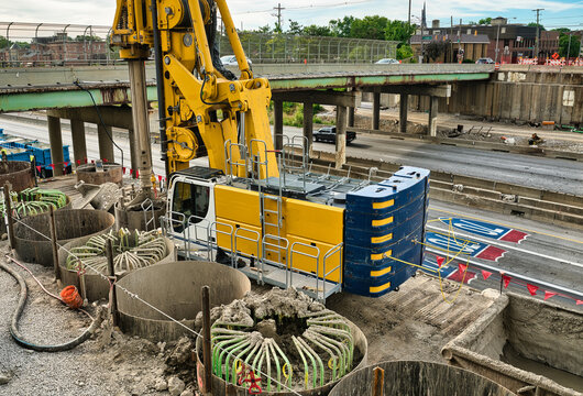 Construction along the I70 I71 freeway in downtown Columbus Oh. A rotary drill on a large excavator boring hole to be filled by rebar reinforced concrete. USA 2026