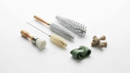 Fototapeta premium Cleaning brushes and tools are arranged carefully on a plain white surface for industrial or maintenance purposes.