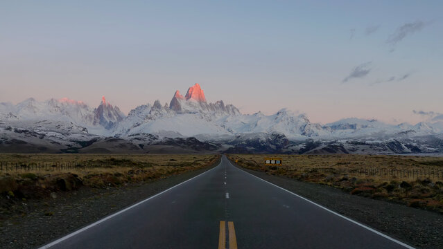 a wide shot of monte fitz roy and the road to el chalten at sunrise after an autumn snow storm in patagonian argentina