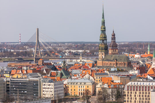 Aerial view of St. Peter's Church and the Vansu Bridge rising above the historic rooftops of the old town in Riga, Latvia.