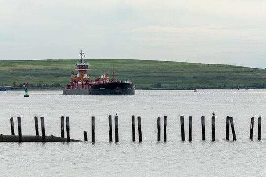 SEWAREN, NEW JERSEY - JUNE 19, 2026: The articulated tug-barge unit Janice Ann Reinauer and RTC 103, operated by Reinauer Transportation Companies, transit the Arthur Kill waterway.