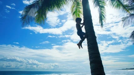 A child climbs a palm tree towards the sun with a bright blue sky and ocean in the background © subur