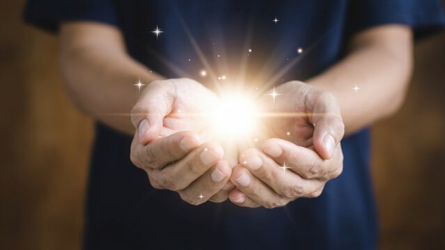 Person holding glowing magic light in cupped hands