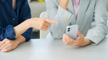 スマホを見る女性とシニア男性 © metamorworks