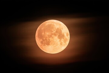 Obraz premium Large, glowing orange orb in the night sky, partially obscured by faint clouds