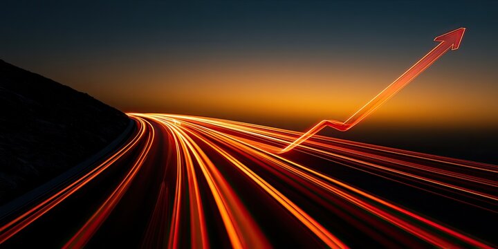 Streaking lights on a curved road ascend into a bright orange and dark blue sky