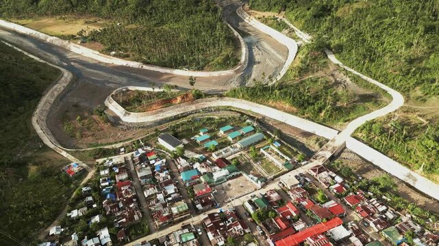 Obi, Caramoran, Catanduanes, Philippines - A Winding Mountain Road Passes Above the Community, Surrounded by Lush Green Hills - Aerial Ascend Shot