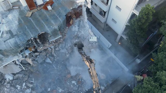 Slow orbital drone view of residential building demolition during urban renewal redevelopment, פינוי בינוי, תמא 38, construction and city transformation.