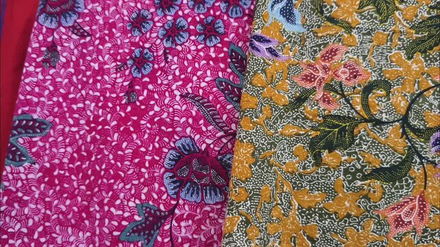 4K footage of vibrant and colorful Javanese batik textiles stacked together, showcasing rich cultural patterns and background texture.