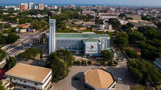 Aerial view of the Holy Spirit Cathedral in Accra, surrounded by lush trees, urban streets, and the cityscape of Accra, Greater Accra Region, Ghana.