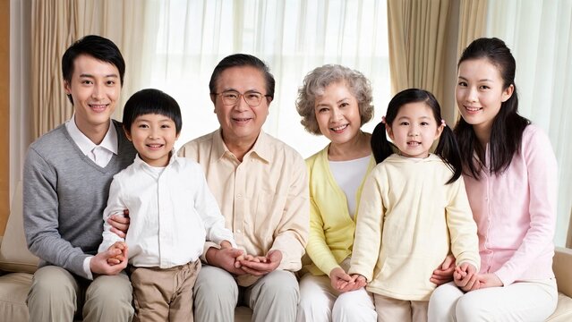 Happy multi-generation Asian family portrait sitting on sofa at home, grandparents parents and children smiling together, love unity togetherness lifestyle concept.