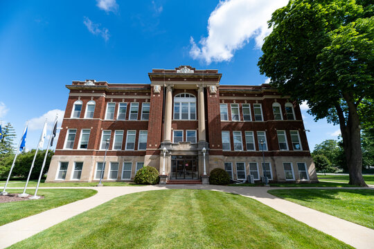 Symmetrical Front Facade of Historic Sanilac County Courthouse with Flagpoles and Manicured Lawn