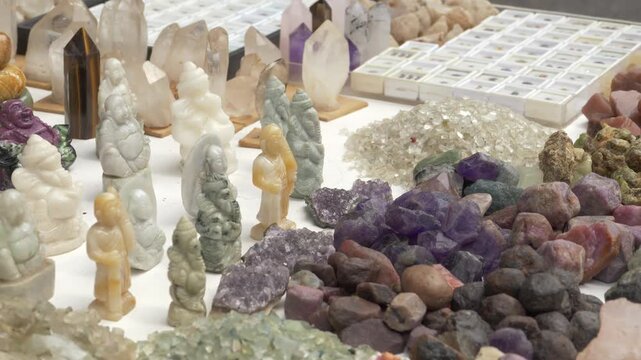Piles Of Raw Purple Amethyst, Crystals, And Carved Statuettes Displayed At Chanthaburi Gem Market In Thailand. close-up shot