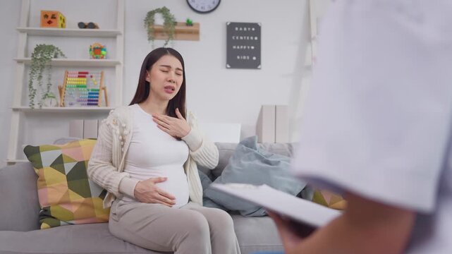 Asian pregnant woman consults with doctor at maternal health center. 