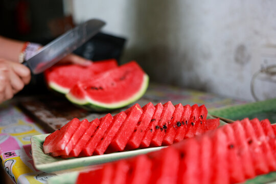 Sliced watermelon red fruit juicy fresh summer dessert healthy sweet kitchen hand cutting watermelon creates vibrant and refreshing atmosphere