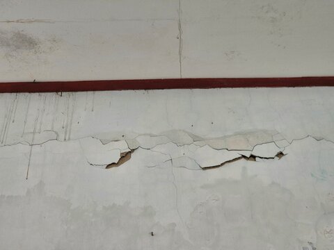Peeling Paint on Interior Wall Beneath Trim Showing Building Deterioration and Damage