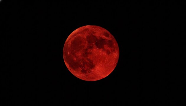 A bright red moon glows in the dark night sky with a mysterious and serene atmosphere.