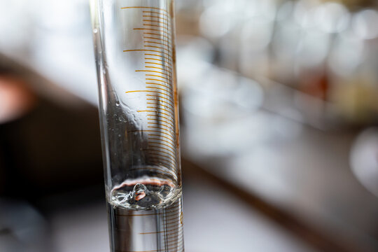 Close up glass hydrometer alcohol measurement clear liquid laboratory distillation scientific equipment transparent precise vertical focus blurred background gin distillation alcohol distillation