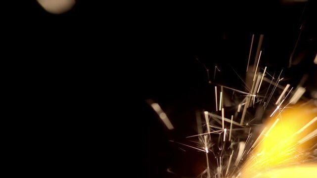 Close up of a lit blasting fuse burning, sparking, and smoking. Glowing sparks flying with flames. Lit detonation fuse with sparks and fire to ignite explosive pyrotechnics.
