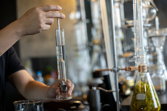 Laboratory distillation alcohol measurement glassware hand liquid science chemistry equipment precision research transparent experiment professional technology scientific clean focus modern process