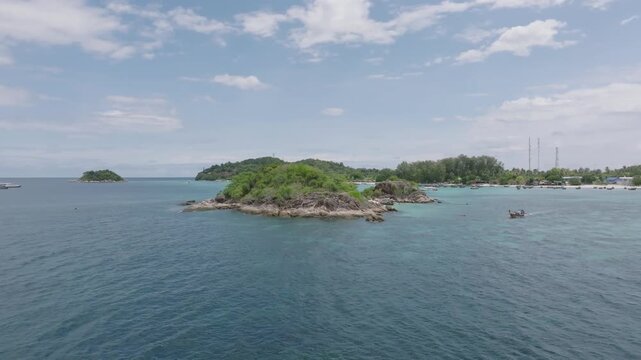 Aerial drone view of Koh Lipe island, Satun, Thailand. Turquoise sea, coral reefs, white sand beaches and traditional long-tail boats in the Andaman Sea.