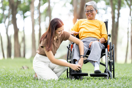 Young Asian Woman Caring for Her Senior Mother in Wheelchair