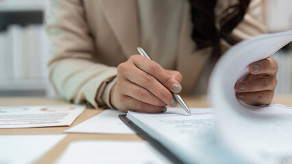 Close-up of hand writing on documents in office © Korakot