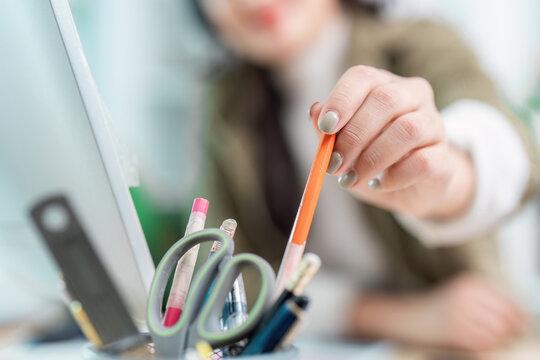 Office worker organizing stationery at desk