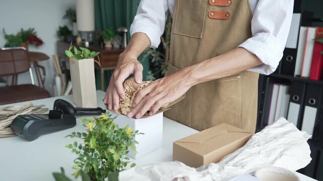 Asian business owner packaging with eco bubble wrap