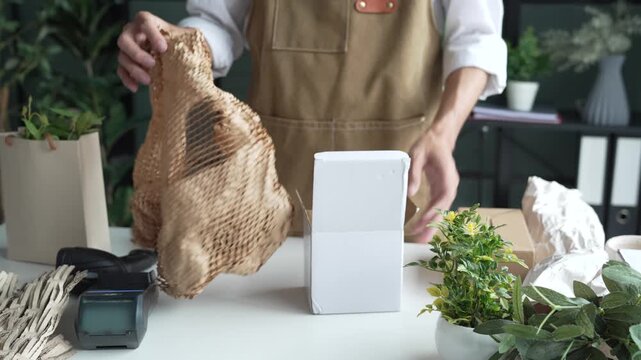 Asian business owner packaging with eco bubble wrap