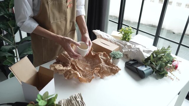 Asian business owner packaging with eco bubble wrap
