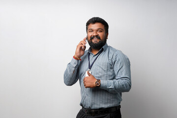 Naklejka premium Young indian male corporate employee talking on mobile phone