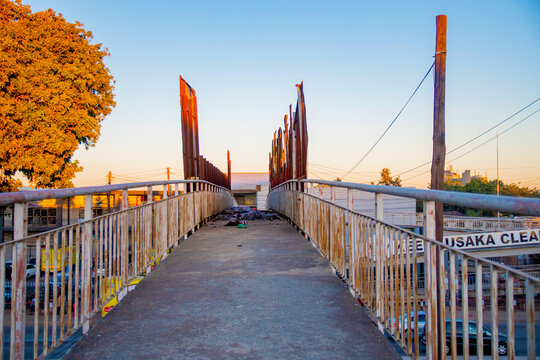 Lusaka, Zambia - 12 June 2026: View of a pedestrian footbridge with metal railings and wooden posts in the city center during the golden hour.