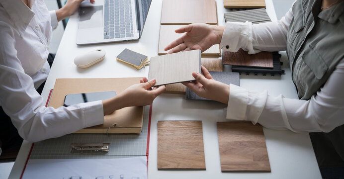 Interior designer presenting eco friendly wooden material samples for sustainable home decor