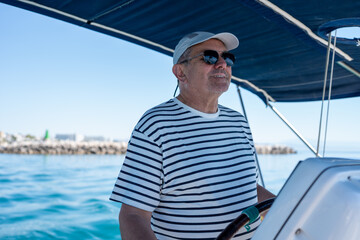 Fototapeta premium Senior man steering sailboat enjoying summer vacation